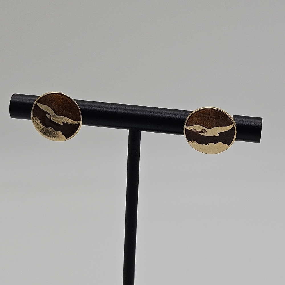 gold tone stud earrings with bird flying over mountains imagery